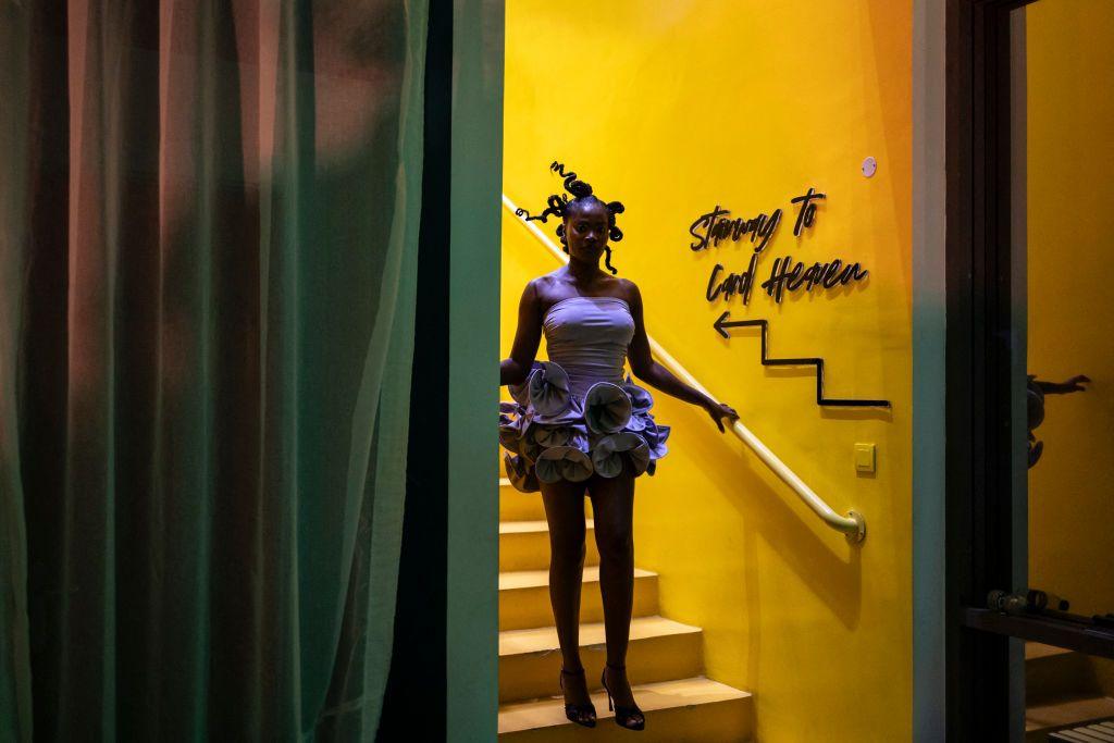 A guest wearing a lilac minidress walks down a bright yellow staircase during a private fashion show of the brand Kadiju during Lagos Fashion Week on 27 October.