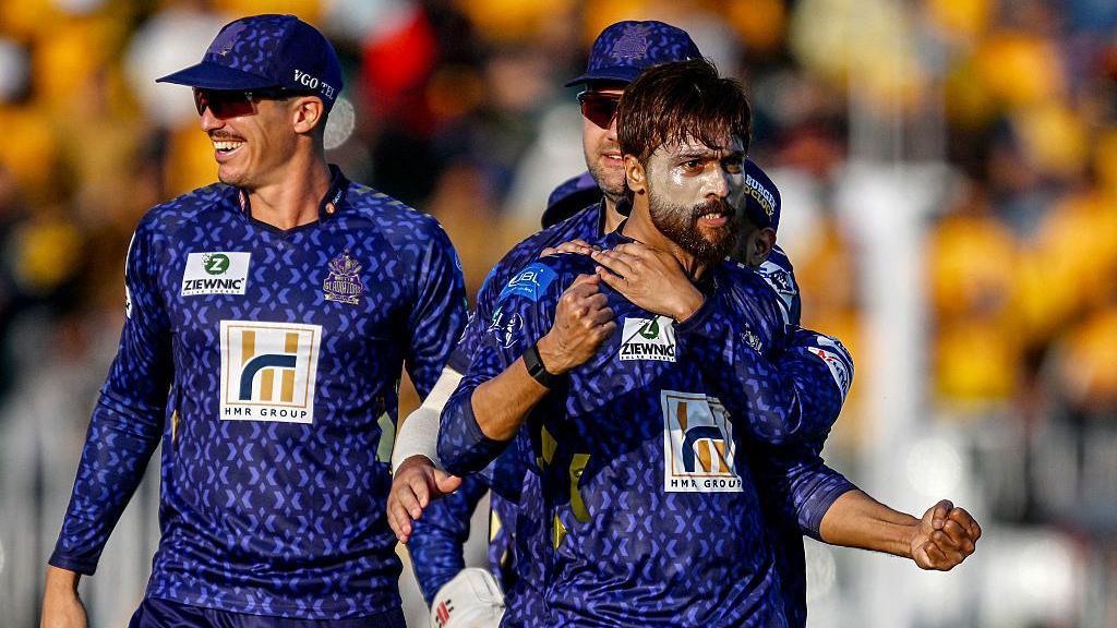 Quetta Gladiators' Mohammad Amir (R) celebrates with teammates after taking the wicket of Peshawar Zalmi's Babar Azam during the Pakistan Super League (PSL) Twenty20 cricket match between Peshawar Zalmi and Quetta Gladiators