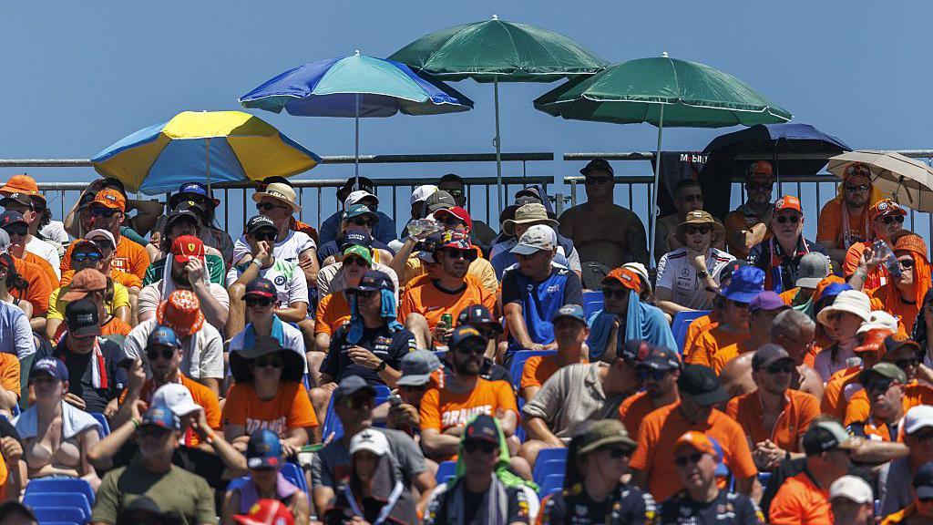 Fans sit under umbrellas during qualifying in Austria 