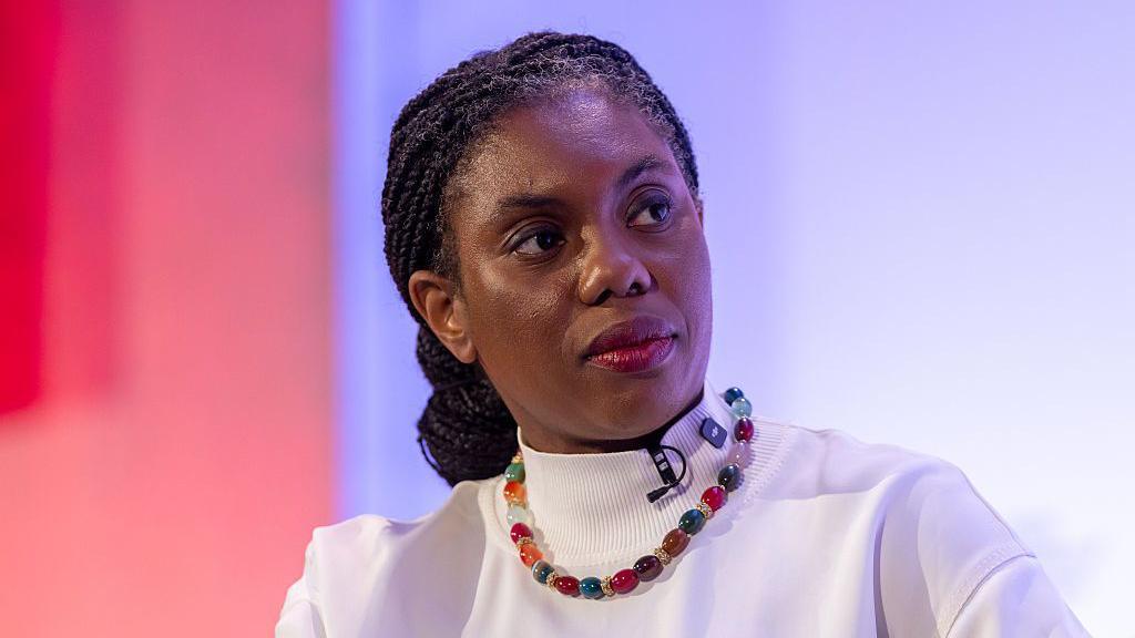 Kemi Badenoch, leader of the Conservatives seen wearing a white short sleeved top and beaded necklace.
