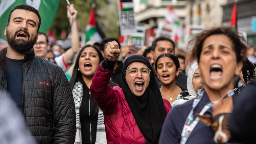 Protesters in central London chant during a pro-Palestinian demonstration - one woman has her fist raised in the air 