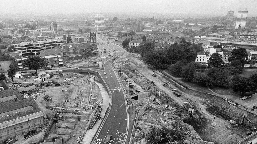 The Coventry Ring Road under construction in 1973, a black and white photo showing the start of a road snaking through a city  with buildings either side