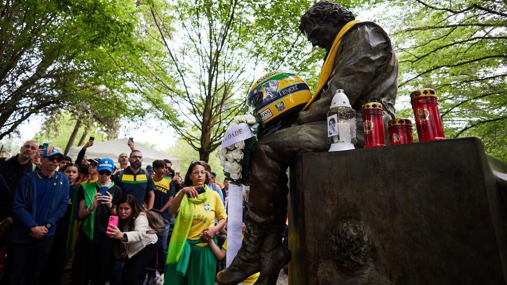 Fans leave tributes to Ayrton Senna at the memorial statue in Imola 