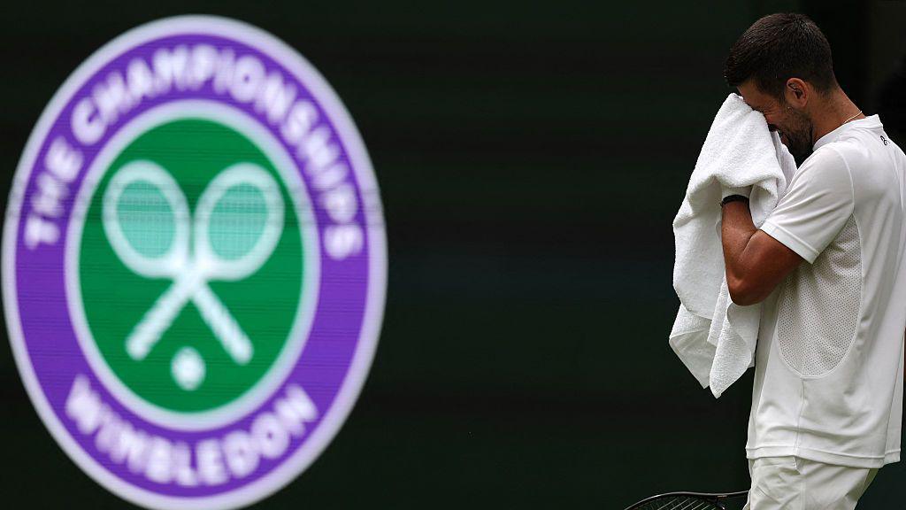 Serbia's Novak Djokovic wipes sweat from his face as he practices
