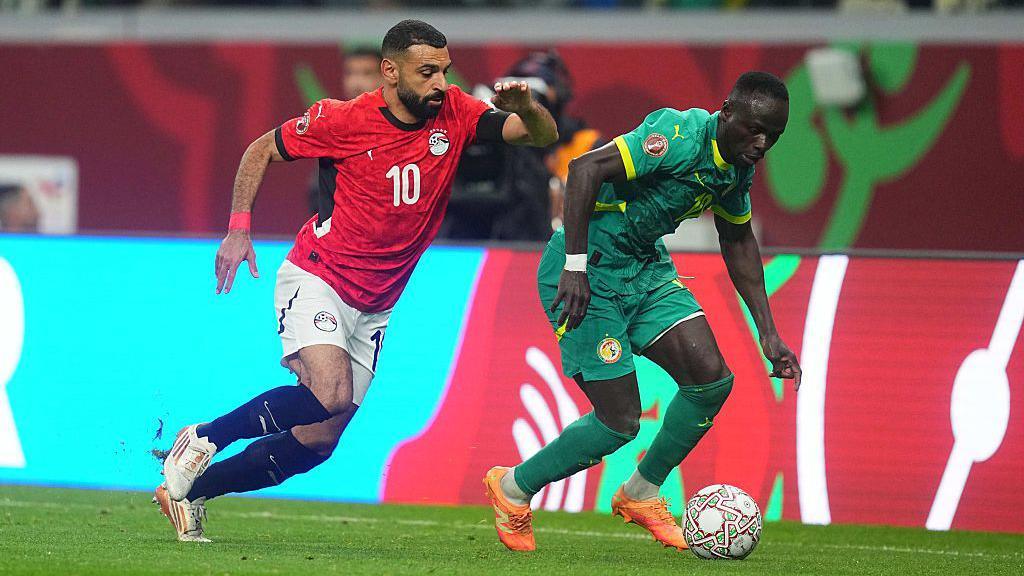 Mo Salah trying to tackle Sadio Mane