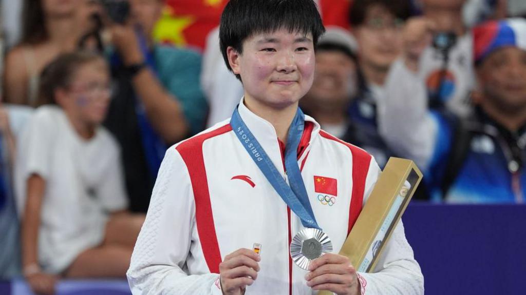 He Bingjiao holding tiny Spanish flag.