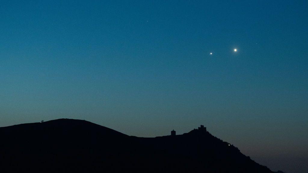 Planets Jupiter and Venus in conjunction rise before sunrise behind Rocca Calascio castle in Italy in 2022.