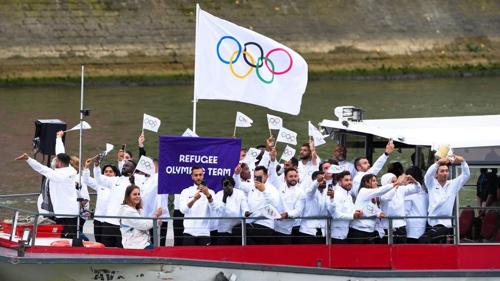  Athletes from Refugee Olympic Team delegation sail in a boat along the river Seine as rain starts at the start of the opening ceremony of the Paris 2024 Olympic Games in Paris