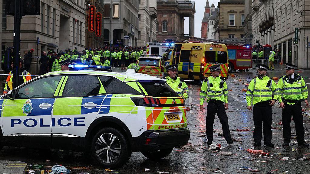 Police officers stand on duty at a cordon at the entrance to Water Street, at the scene of an incident, which happened during the open-top bus victory parade for Liverpool's Premier League title win.