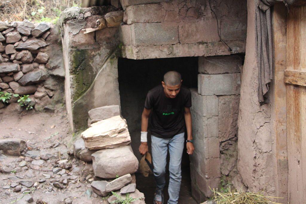 A resident of Bakoat village walks through the entrance of a bunker prepared for protection from cross-border fire