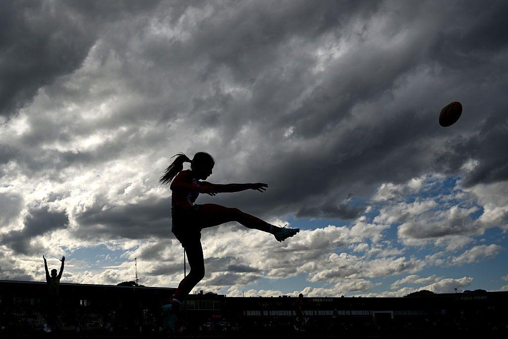 A silhouette of St Kilda Saints' Georgia Patrikios kicking the ball during the AFLW match against Collingwood in Melbourne.