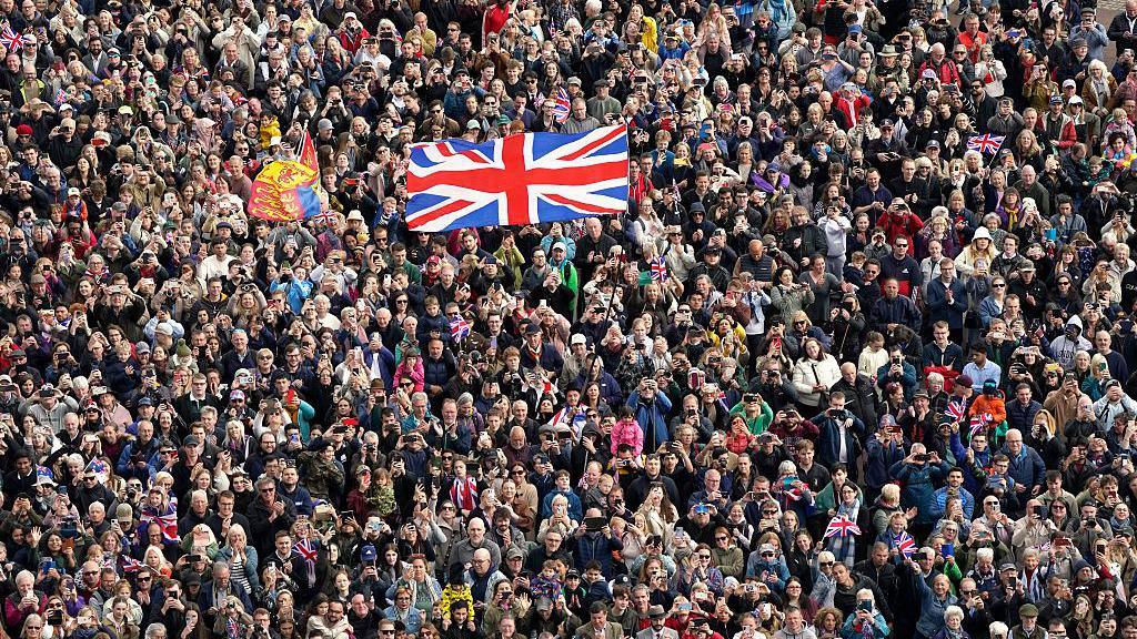 Huge crowds gather to watch the military fly pass over The Mall in London