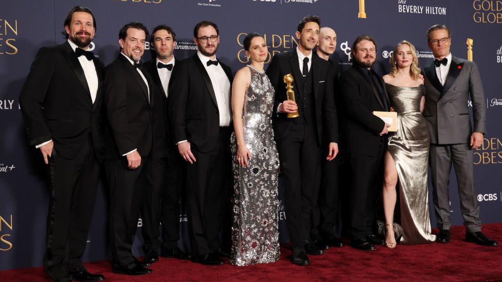 Trevor Matthews, Brian Young, Felicity Jones, Adrien Brody, winner of the Best Performance by a Male Actor in a Motion Picture – Drama Award for "The Brutalist," Daniel Blumberg, Brady Corbet, Mona Fastvold, and Guy Pearce pose in the press room during the 82nd Annual Golden Globe Awards at The Beverly Hilton on January 05, 2025 in Beverly Hills, California.