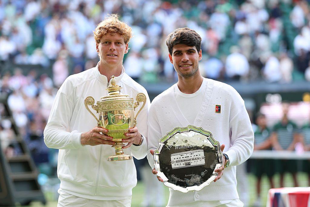 Jannick Sinner (left) and Carlos Alcaraz (right) pose with their trophies at Wimbledon in 2025