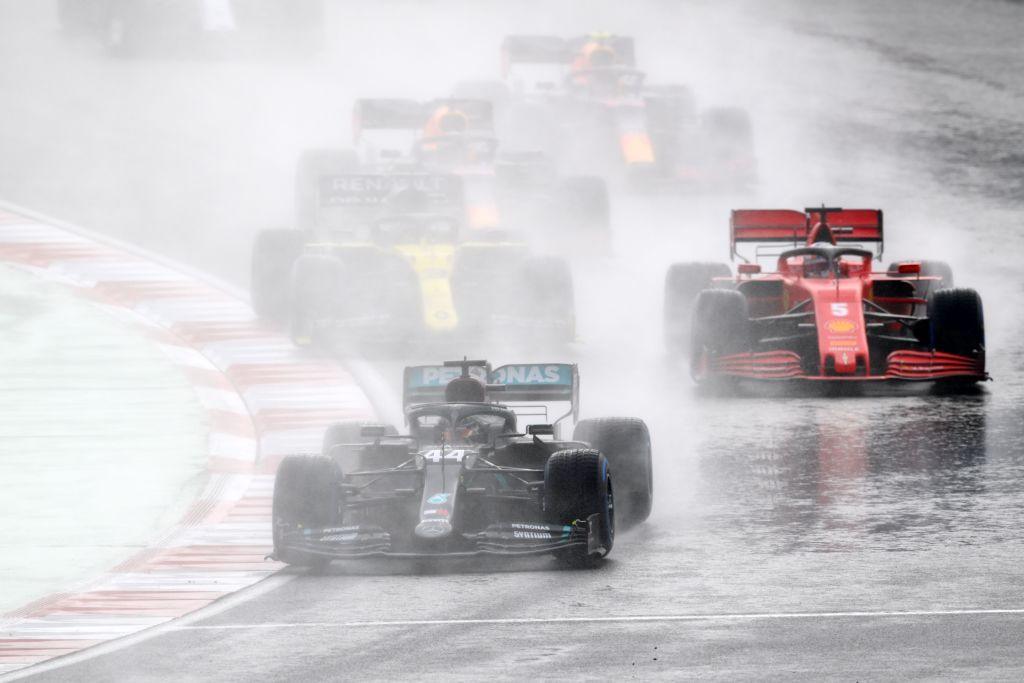 Lewis Hamilton leads a train of cars in wet conditions at the 2020 Turkish Grand Prix, with Ferrari's Sebastian Vettel immediately behind him