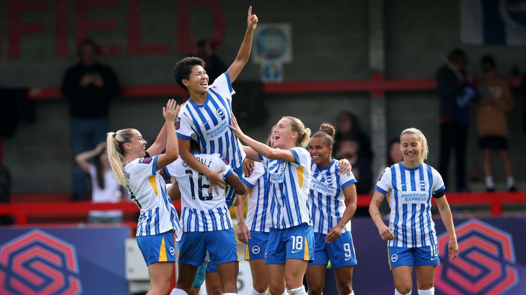 Kiko Seike is lifted up by her Brighton team-mates after completing her hat-trick