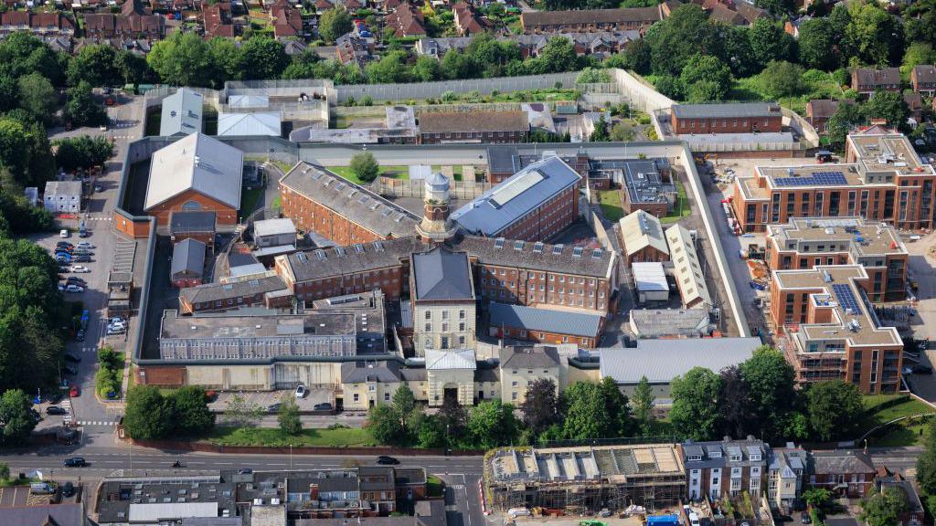 An aerial photo of the prison. It's a square complex with buildings arranged in a star shape around a central tower.