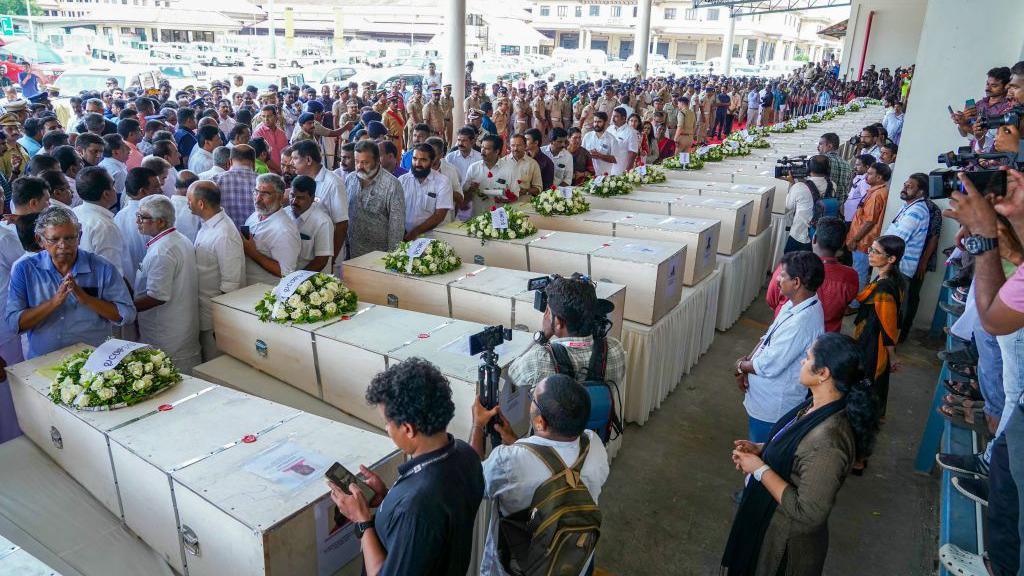 Relatives mourn near the deceased after the coffins' arrival on an Indian Air Force plane from Kuwait at the Cochin International Airport in Kochi on June 14, 2024. Grieving families kept a solemn vigil in the terminal of an Indian airport on June 14 as the bodies of dozens of migrant workers killed in a Kuwait building fire returned home. Wednesday's dawn blaze quickly engulfed a housing block home to some of the many foreign labourers servicing the oil-rich gulf state's economy