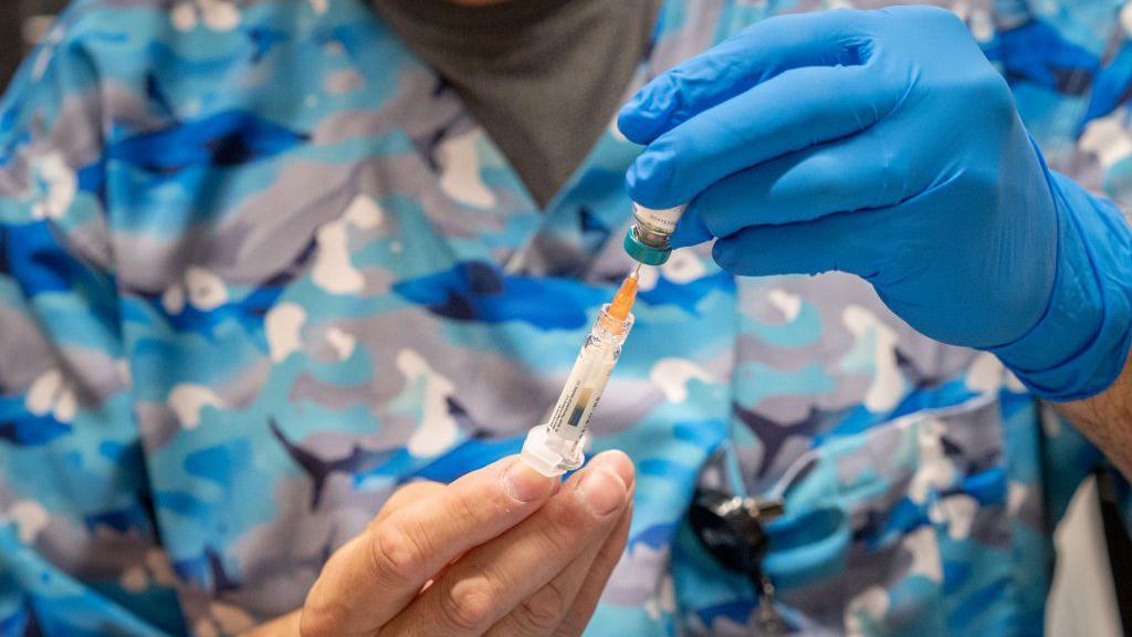 Medical professional fills syringe with drug 