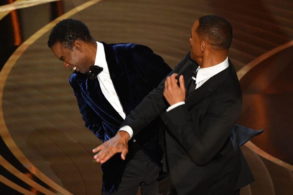 Will Smith slaps Chris Rock onstage during the 94th Oscars. Both are in formal attire