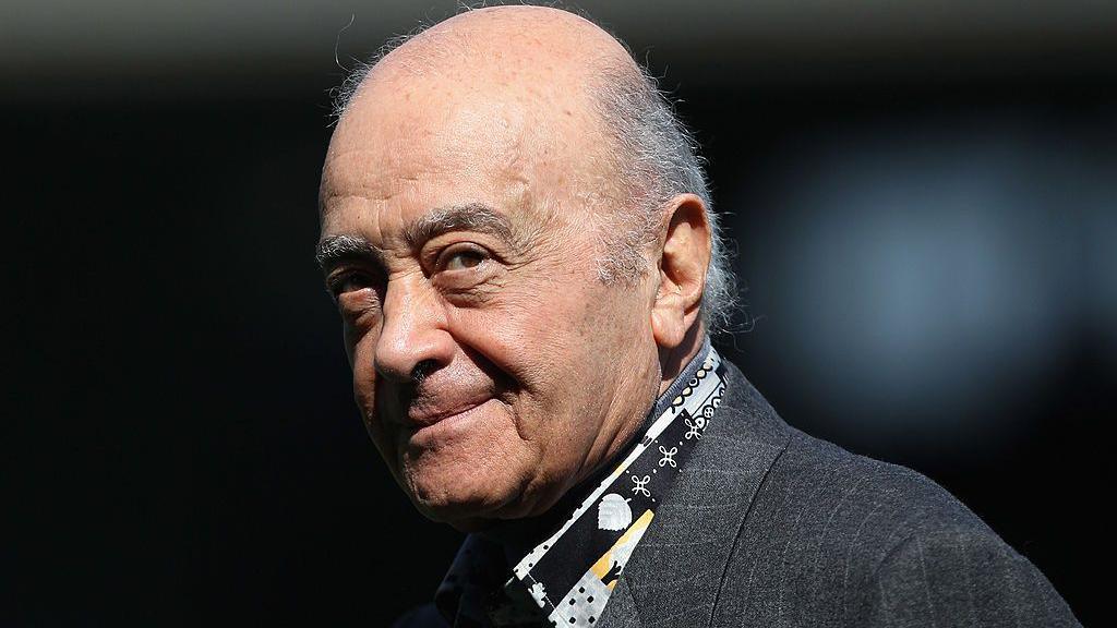 Mohamed Al Fayed is pictured at a football match wearing a grey suit jacket and a patterned black, grey and yellow shirt. He is balding with grey hair to the sides. At the time he was the Fulham chairman and is pictured ahead of the Barclays Premier League match between Fulham and Wolverhampton Wanderers at Craven Cottage on April 17, 2010 in London.