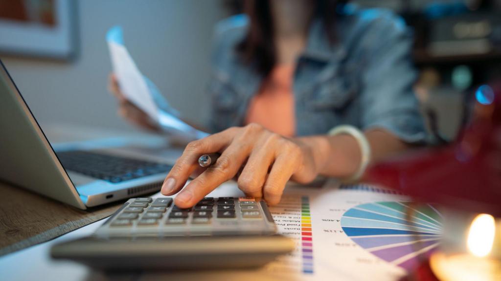 A close up of a hand pressing on calculator for counting about monthly expense