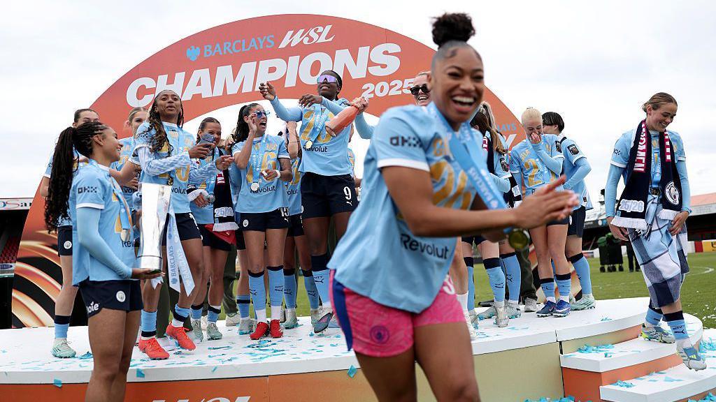 Manchester City players celebrate with the WSL trophy