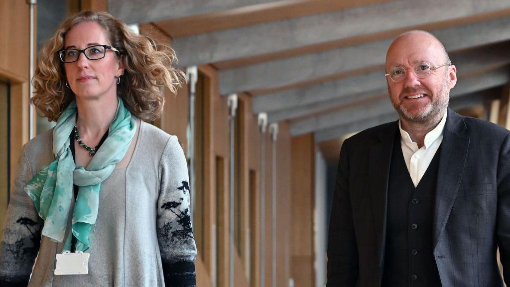 Lorna Slater and Patrick Harvie walking in the Scottish Parliament building 