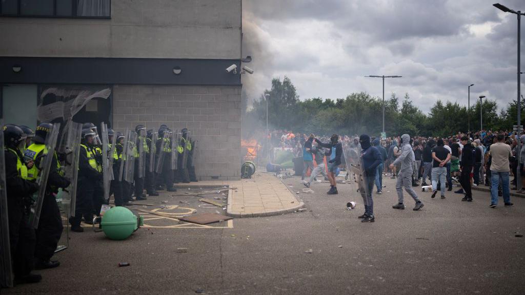 Riot police outside a hotel in Manvers, near Rotherham