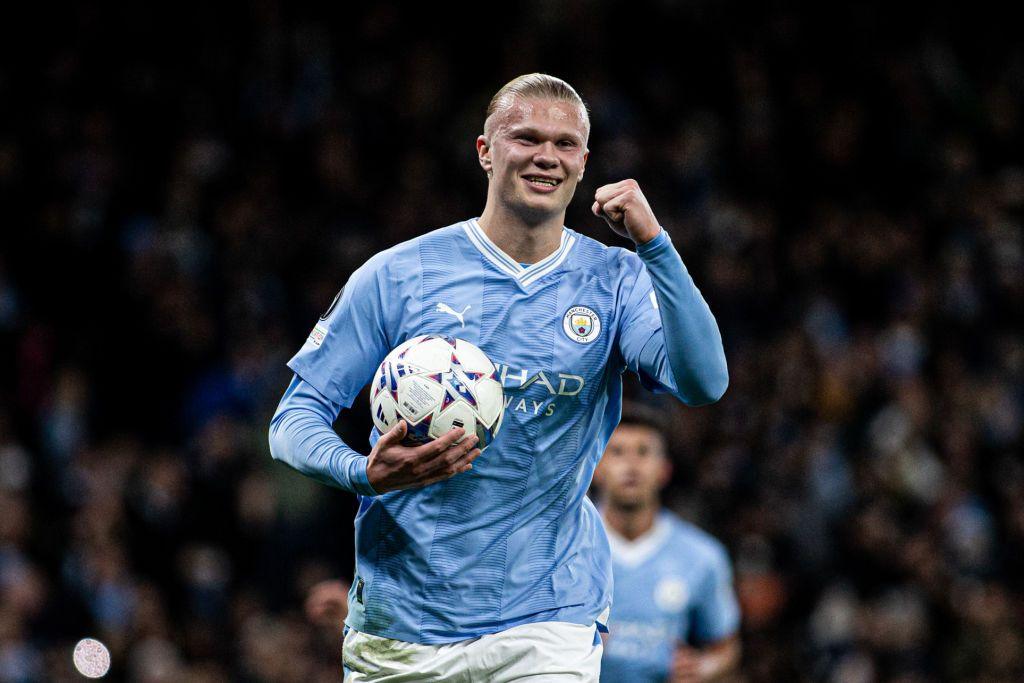 Erling Haaland celebrates, while holding the match ball. 