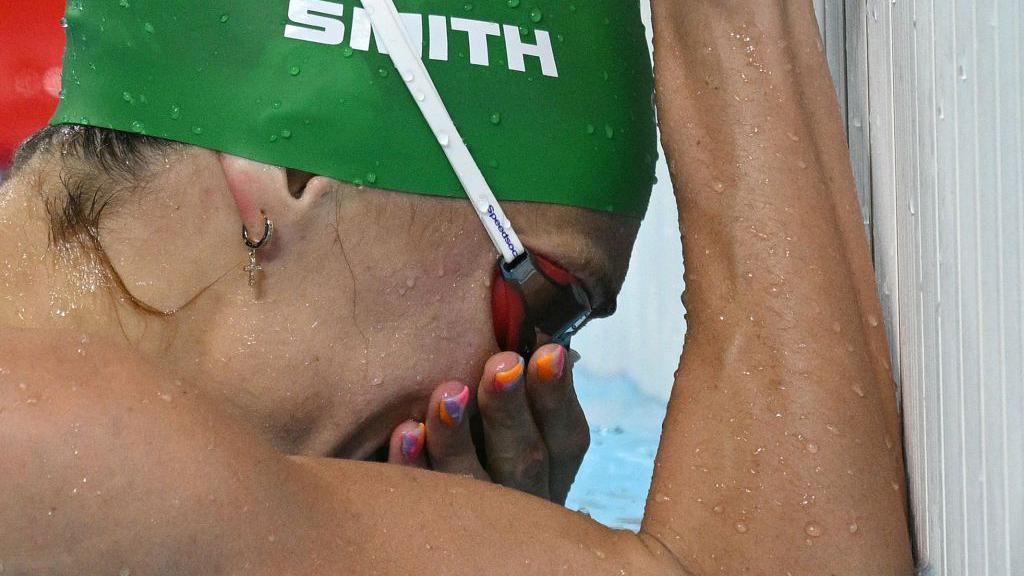 An image of South African swimmer Tatjana Smith with her head in her hands after winning the 100m breastroke on 29 July 2024.