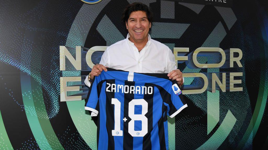 Ivan Zamorano holding up his famous number 1+8 shirt 