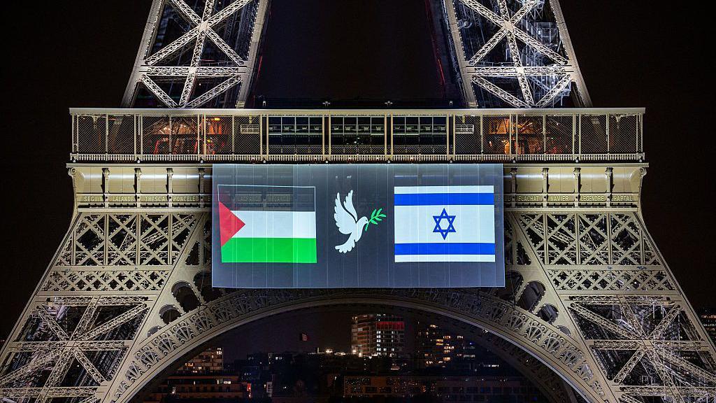 Paris City Hall projected an image onto the Eiffel Tower featuring the Palestinian (L) and Israeli (R) flags, along with a dove holding an olive branch, in Paris on September 21, 2025
