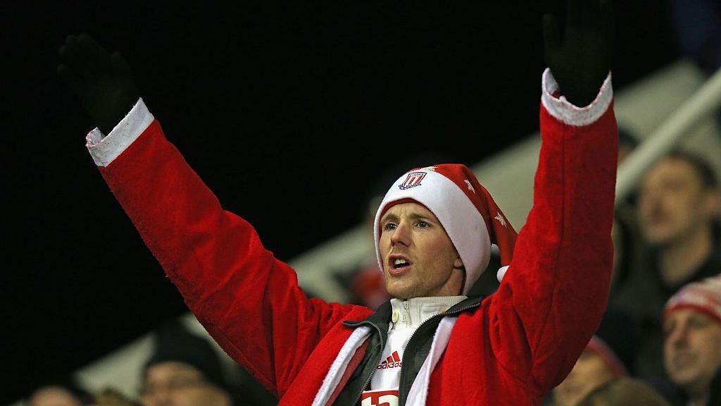 A Stoke City fan is appropriately dressed for Christmas as he enjoys his side's win over Liverpool on Boxing Day 2012