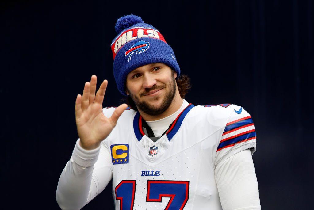 Buffalo Bills quarterback Josh Allen waves while wearing the team uniform and a Bills woolly hat