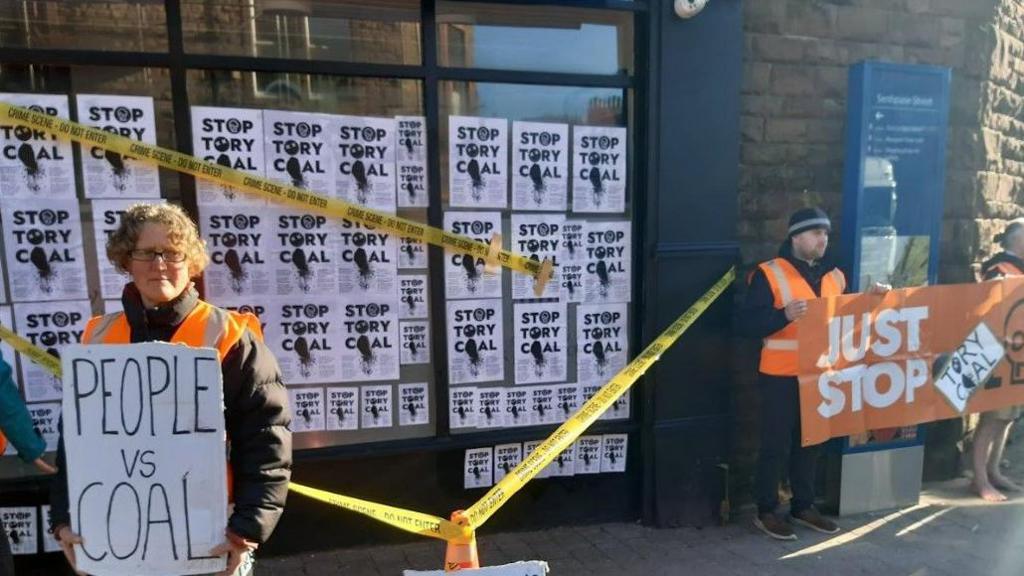 Protesters holding posters outside Mark Jenkinson MP's office on Friday morning