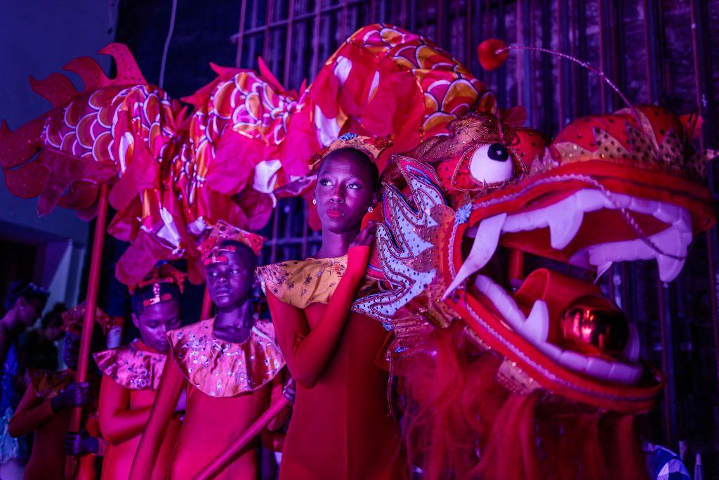 Three dancers dressed in red carry a large, red dragon puppet at the Kenya National Theatre in Nairobi  - Saturday 7 December 2024