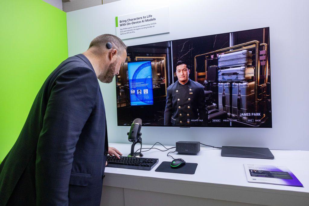 A convention attendee stands in front of a screen displaying a CPU-controlled character in a 3D environment. The man in front of the screen is leaning over a keyboard. A sign above the screen reads "bring characters to life with on-device AI models".