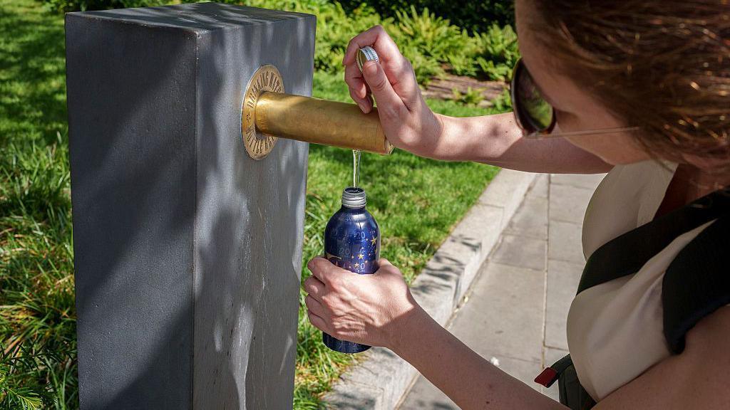 As heatwave temperatures for the month of June remain with a record high of 36.1 Celcius, a visitor to the capital refills her water bottle with free drinking water in the City of London, the capital's financial district, on 25th June 2026