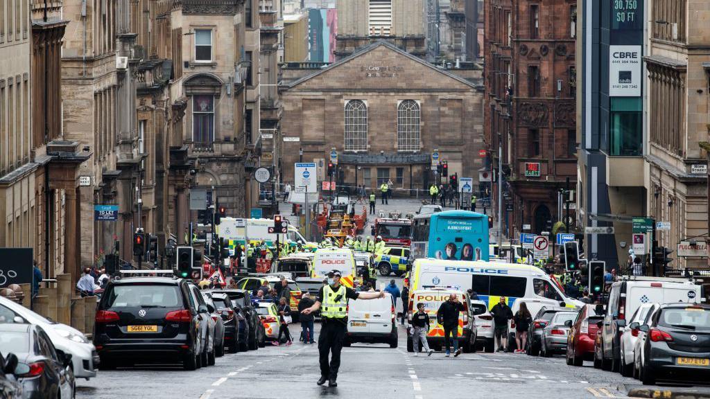 The scene of a Glasgow street following the Park Inn stabbings in 2020. Lots of emergency services are visible.