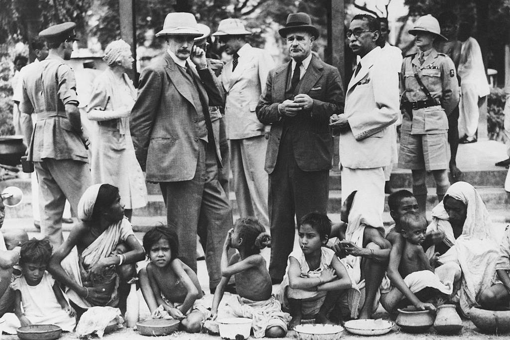 Colonial officials standing above hungry children and adults