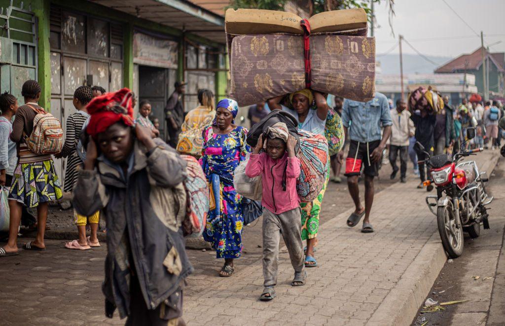 Residents carry their belongings as they flee from Kibati on January 26, 2025