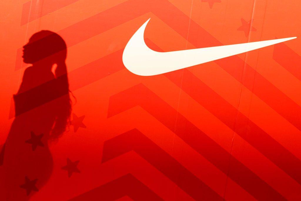 A red background with the shadow of Allyson Felix is seen next to a Nike logo