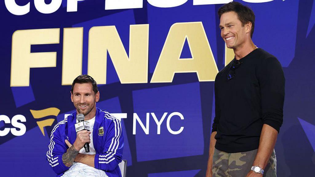 Lionel Messi and Tom Brady speaking on stage at Fanatics Fest before the 2026 World Cup final