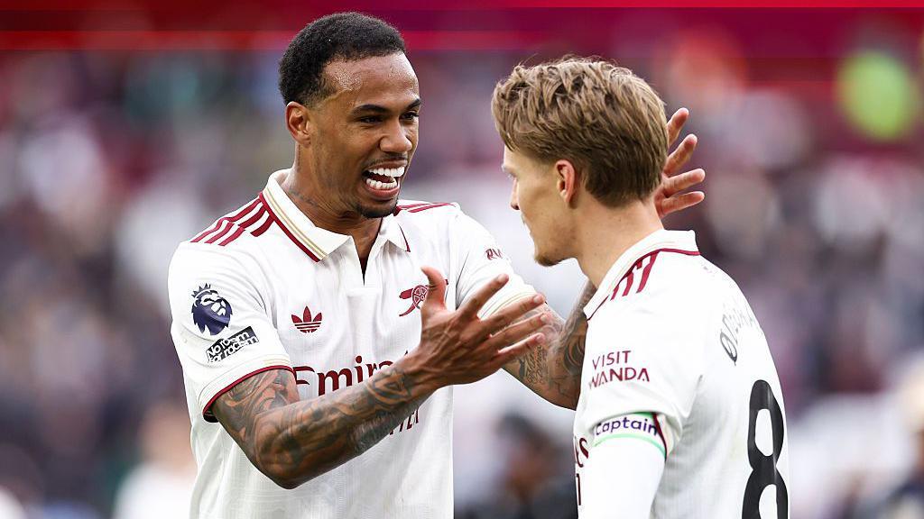An image showing Arsenal players Gabriel and Martin Odegaard celebrating at the final whistle of the Gunners' victory over West Ham