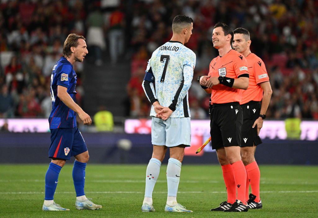 Luka Modric and Cristiano Ronaldo speak to officials in a match