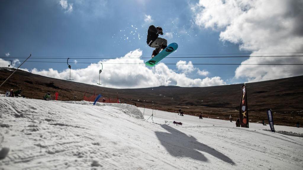 A snowboarder performs a stunt at a slope in Lesotho's Maluti Mountains