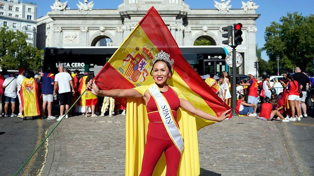 A woman poses with a Spanish flag