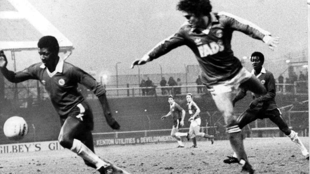 Cardiff City's Gary Bennett, watched by brother Dave, chases the ball during the game against Charlton. An unknown Charlton player is in the air in the foreground.