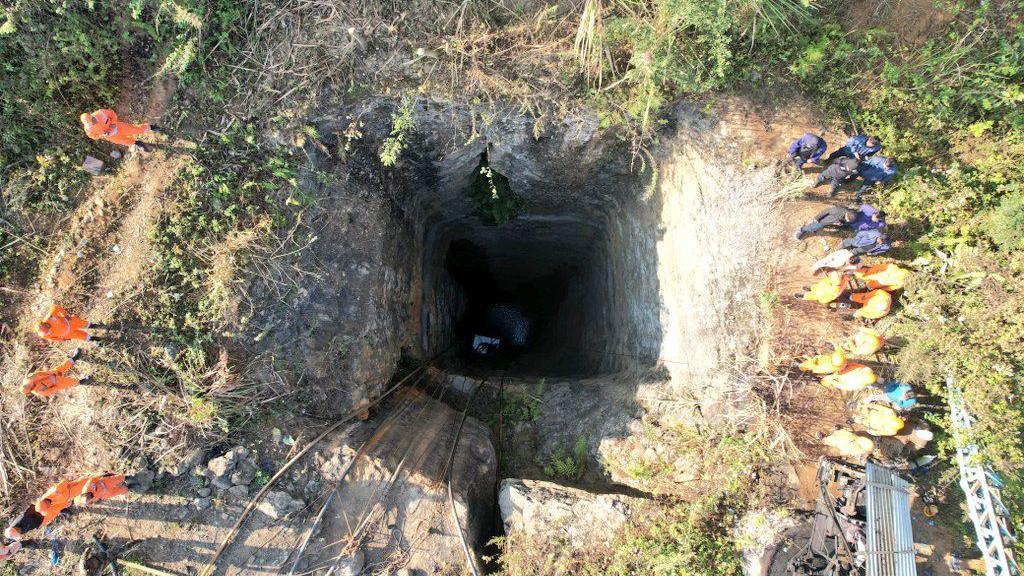 The picture shows a hole, dug dozens of feet inside the earth, in which miners descend to extract coal